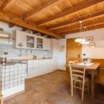 Cucina e tavolo da pranzo della Baita Malga Fravort nel Lagorai
